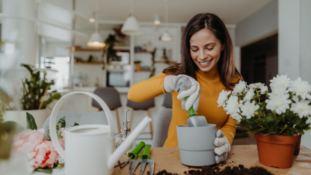 Woman smiles while repotting a plant.